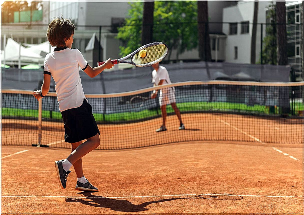 Boy playing tennis.