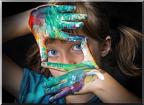 Little girl with her hands full of paint after reading some children's art books.