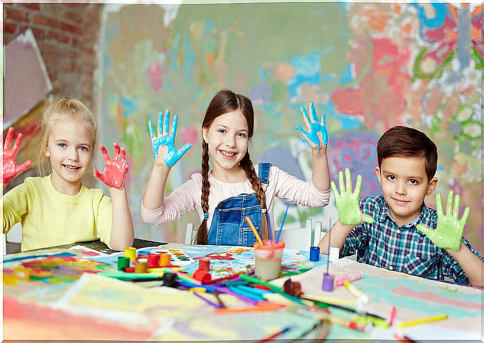 Children making artwork with their hands.