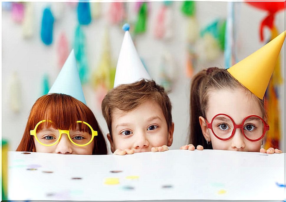 Children celebrating a birthday with hats and confetti