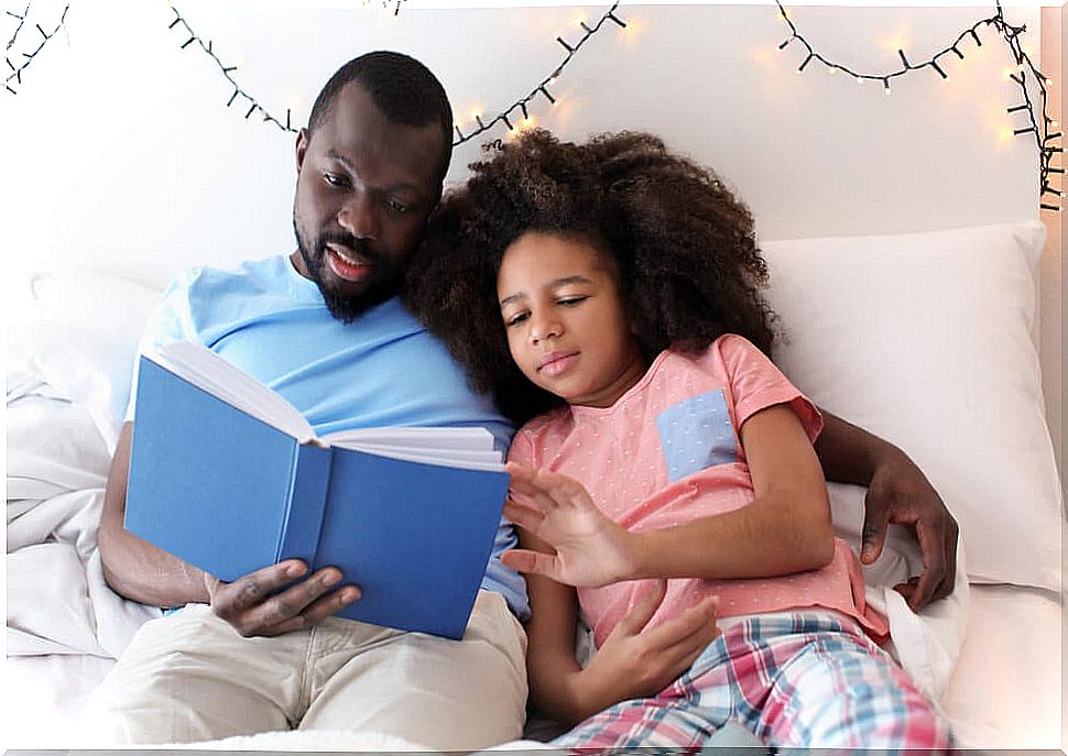 Father reading a bedtime story to his daughter.