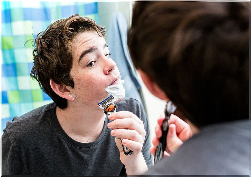 Teen boy shaving.