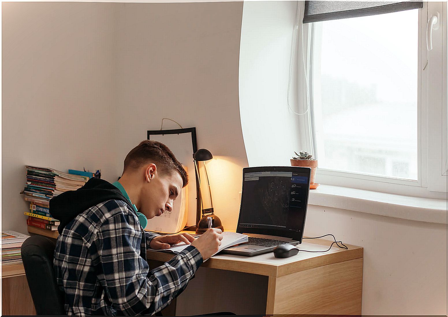 Teen boy studying in his room and thinking about how to choose higher studies.