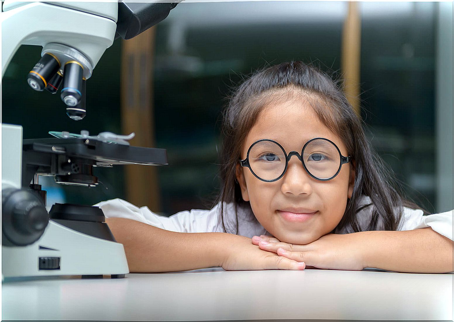 Scientist girl next to a microscope.