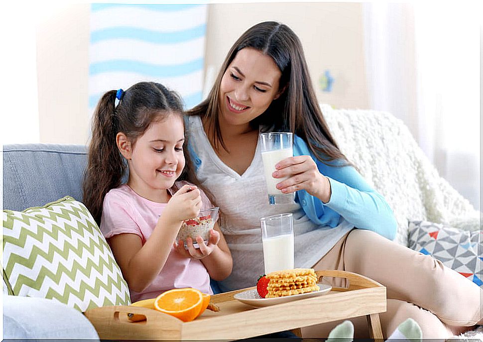 Mother and daughter having a snack of fruit and some dairy products.