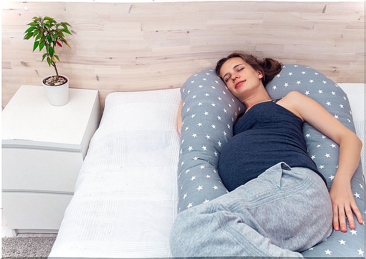 Woman lying with a U-shaped pregnancy pillow.