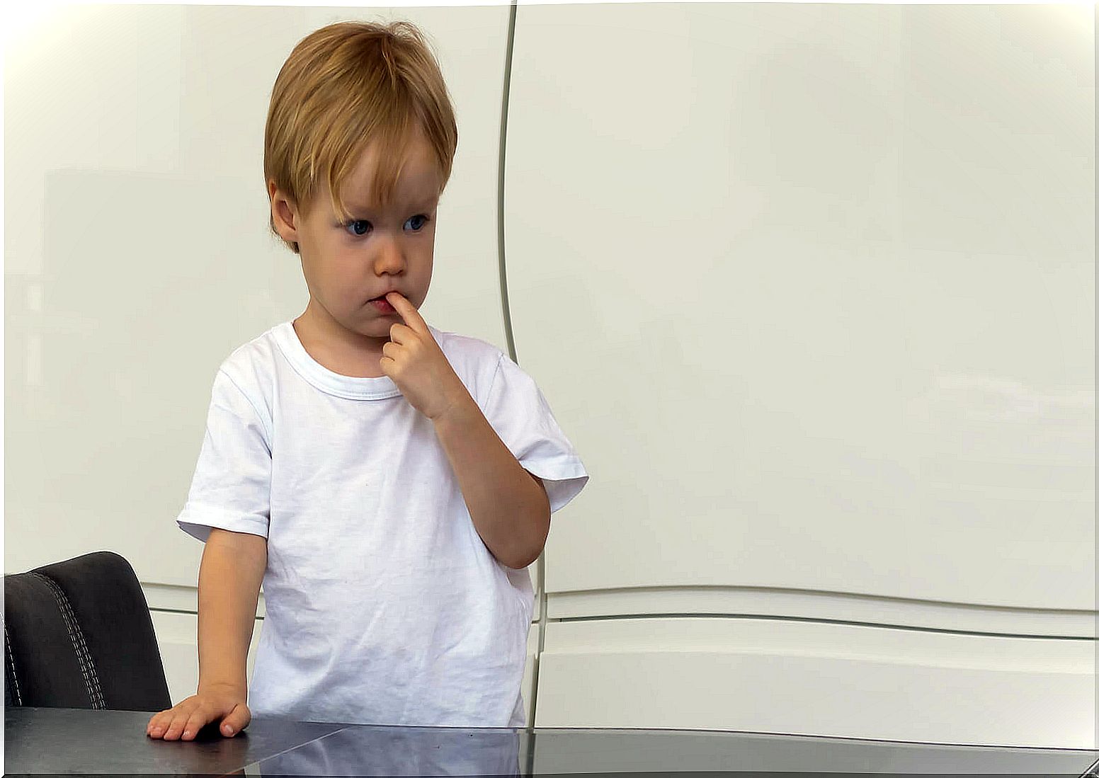 Child with finger in mouth thinking about how to test the limits of his parents.