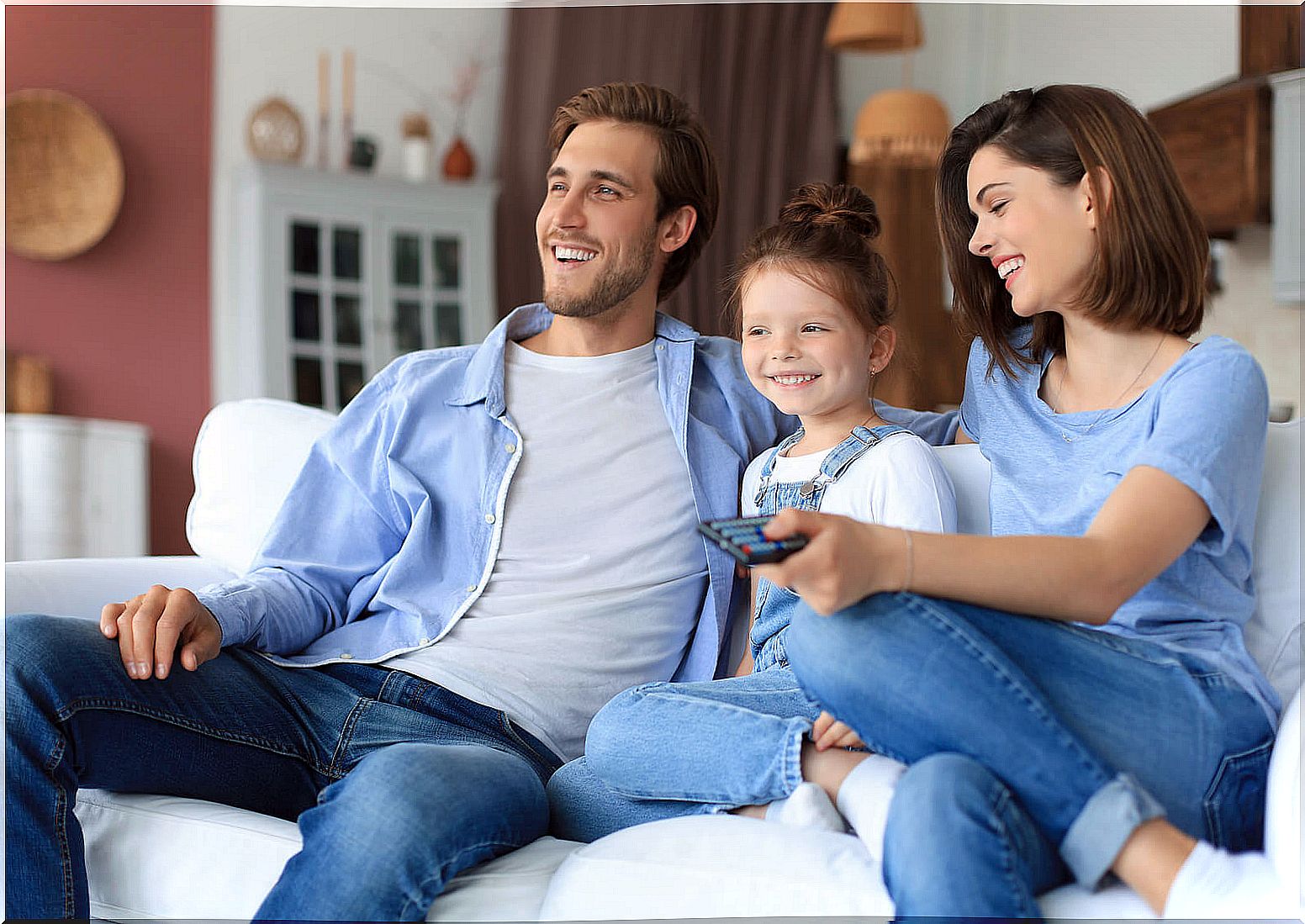 Father watching a movie with his daughter to develop her critical sense.